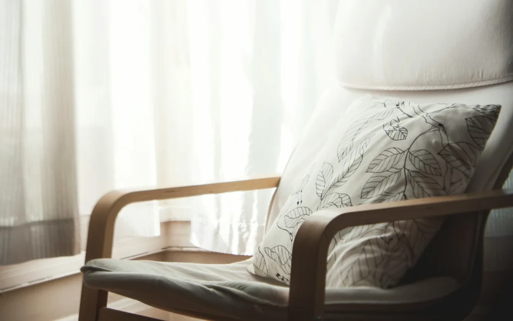 A curtain in the living room next to an armchair