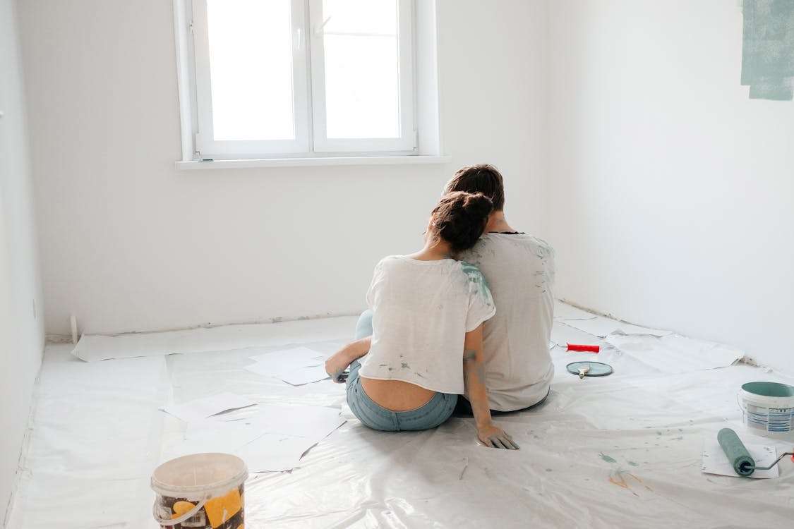 A couple sitting and painting a room