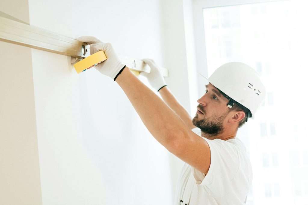 Man installing ceiling lights and crown molding