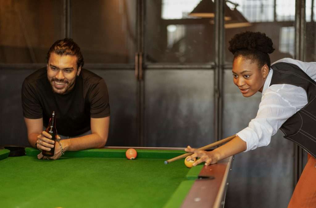 two friends enjoying a game of pool in a game room