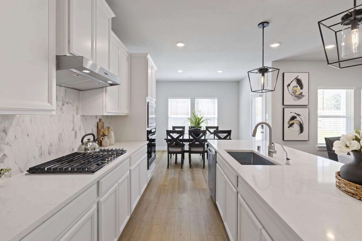 Contemporary kitchen with white cabinets, black hardware, large island, and dining area.
