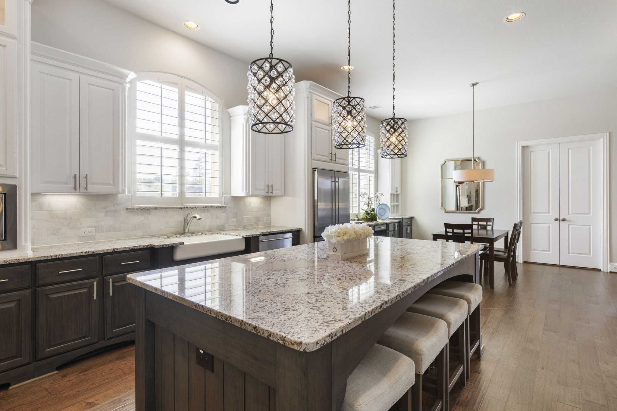 Modern kitchen with granite countertops and elegant lighting Bright kitchen interior with large island and pendant lights