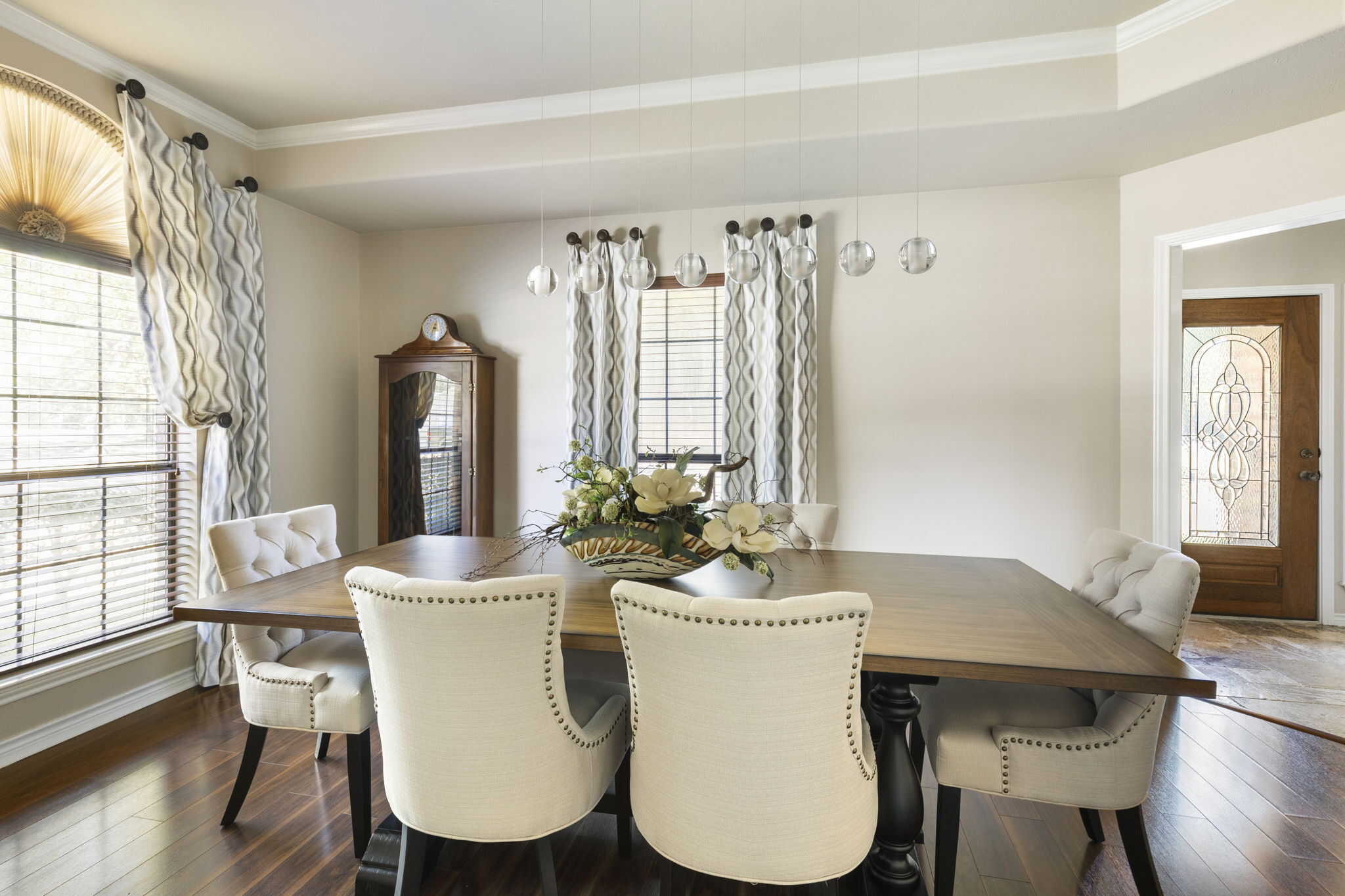 Dining room with custom drapery, patterned window panels, and modern pendant lighting