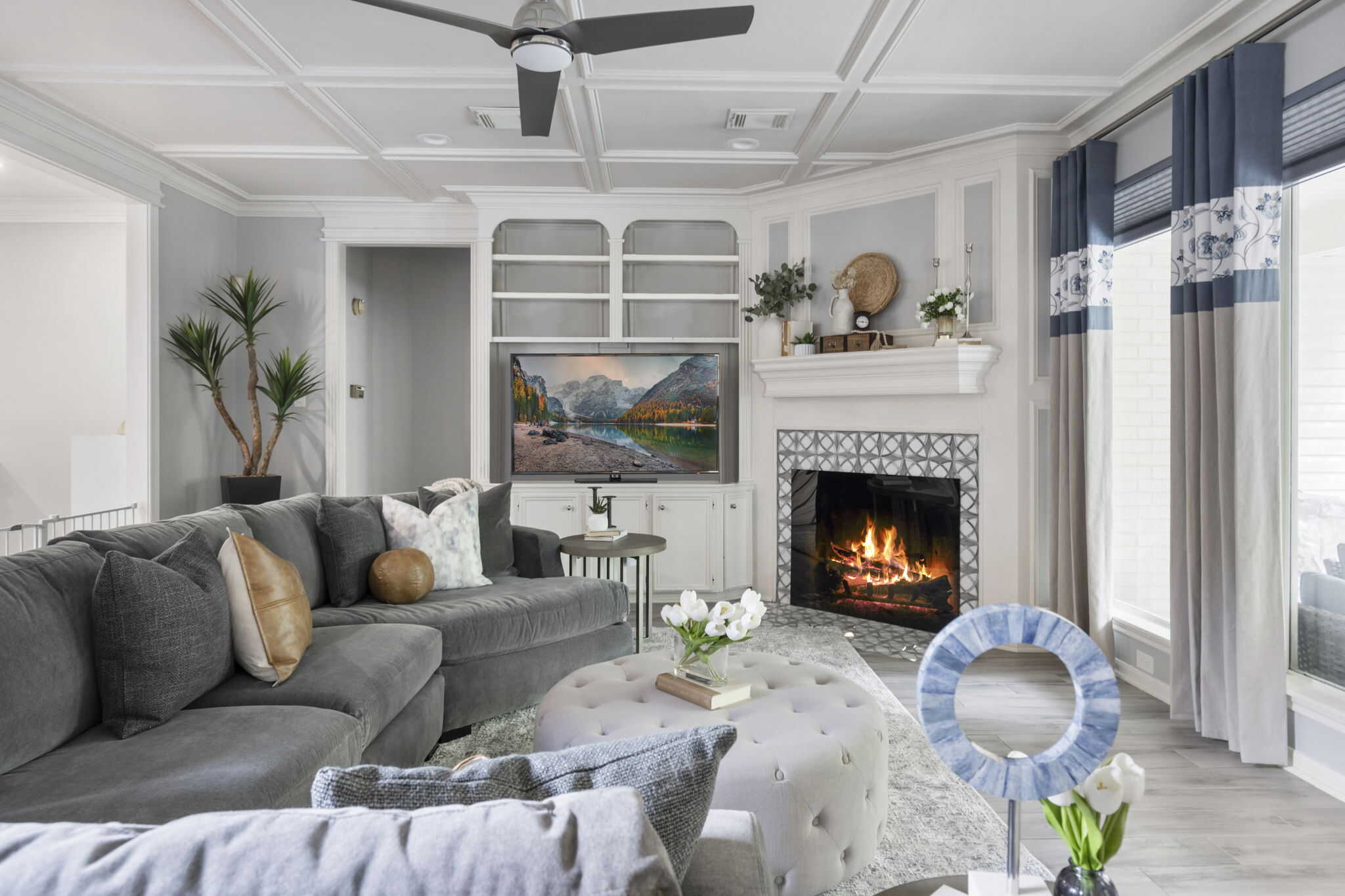 Living room with custom drapery, fireplace, and built-in shelving