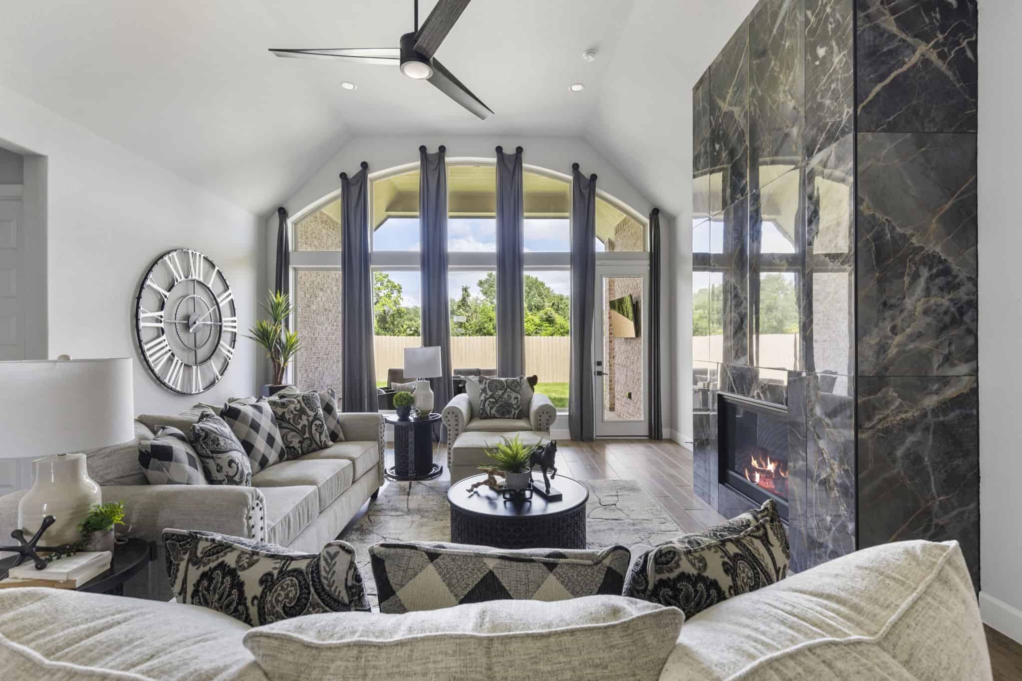 Living room with custom drapery, arched windows, and modern fireplace design