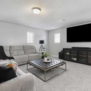 After Renovation – Cozy Living Room with Media Setup Modern living room after renovation with sectional sofa, large wall-mounted TV, coffee table, and neutral decor