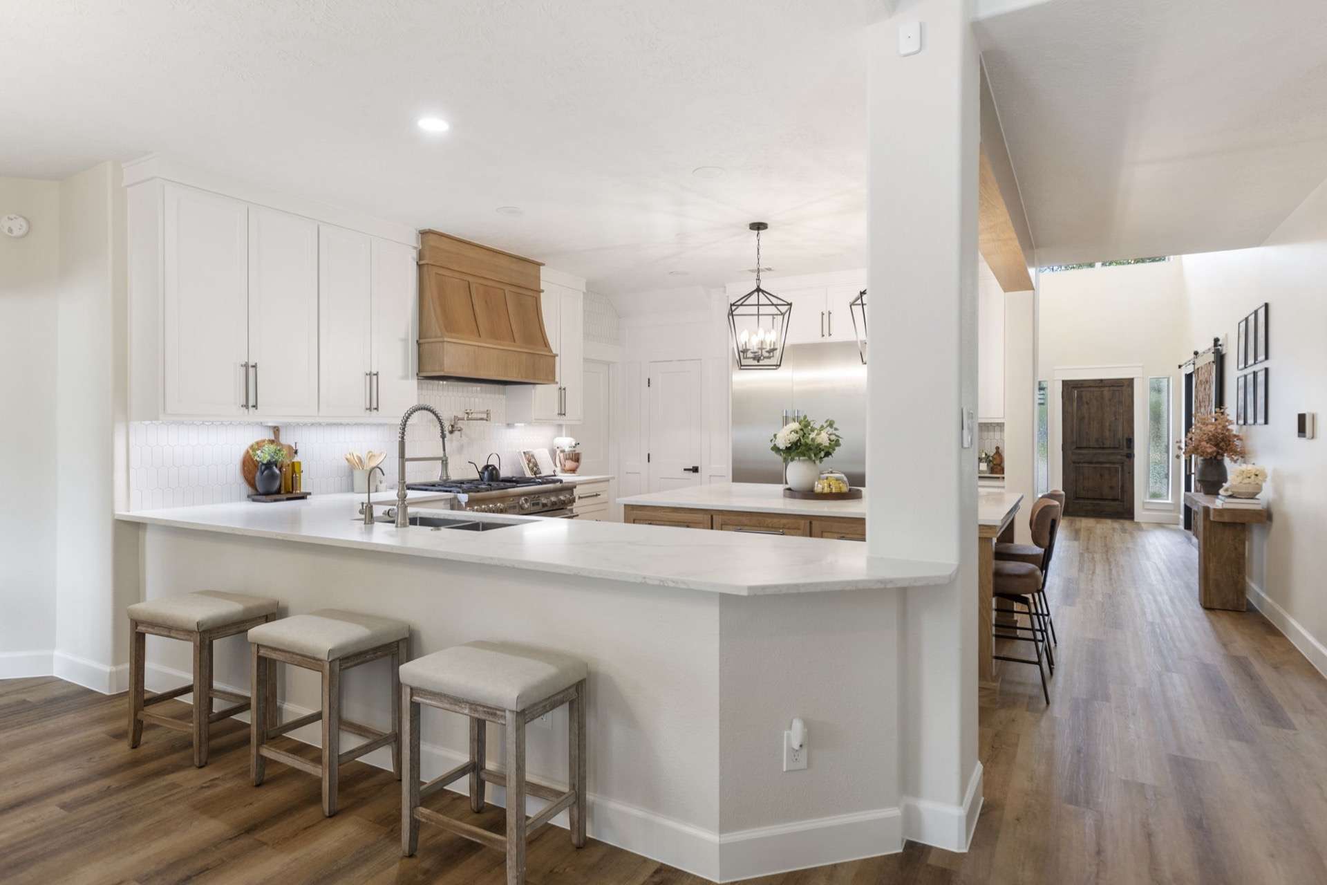 Bright modern open kitchen with quartz peninsula and wide-plank hardwood