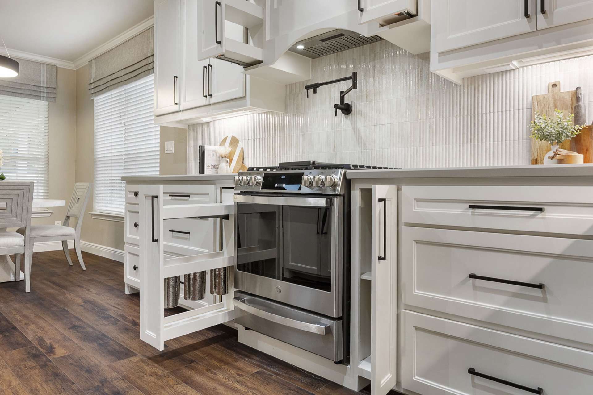 Custom cabinetry with ribbed-tile backsplash and pot filler in a Texas kitchen