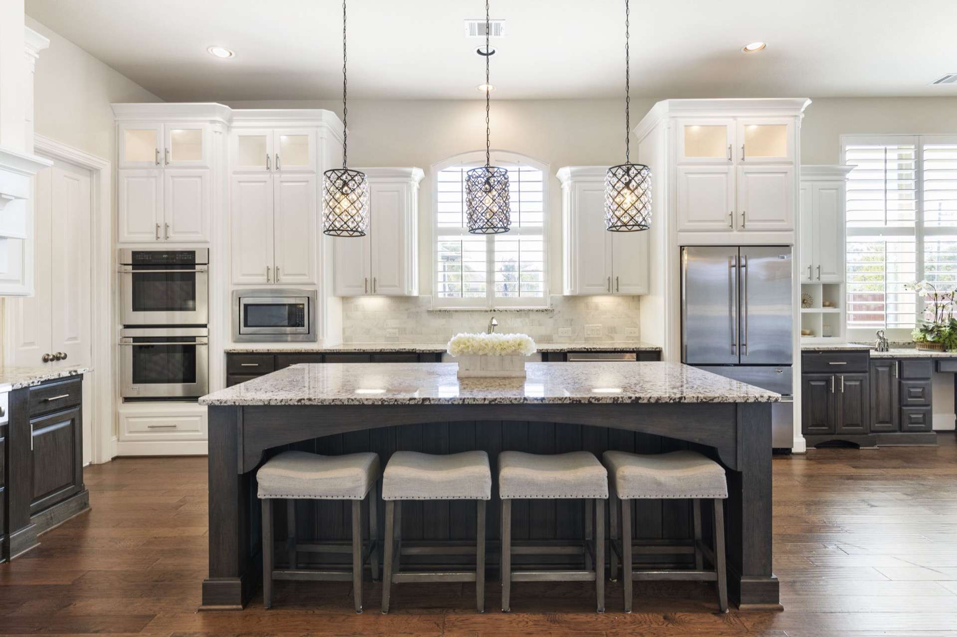 White kitchen remodel with glass pendant lighting and granite island near Conroe, Texas